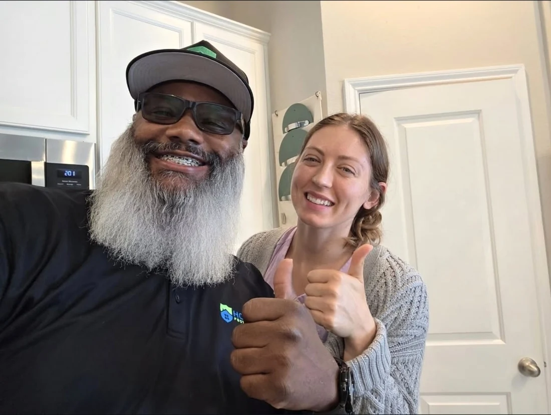 James Wyatt and a woman smiling and giving a thumbs-up in a kitchen